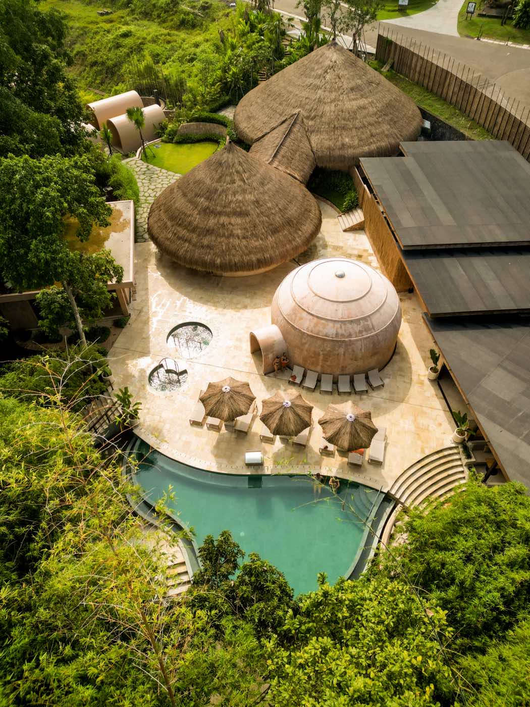 Lumeira from above: the pool winding between thatched pavilions and jungle