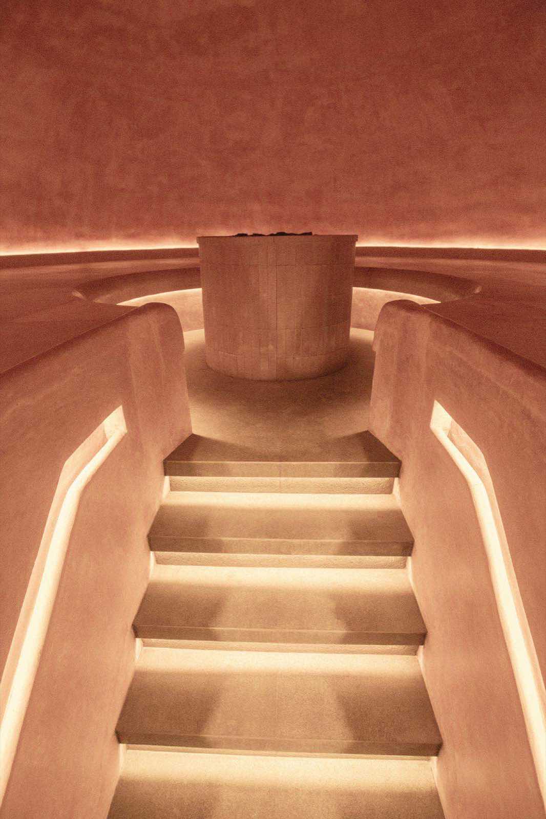 Inside the terracotta sauna, lit steps descending