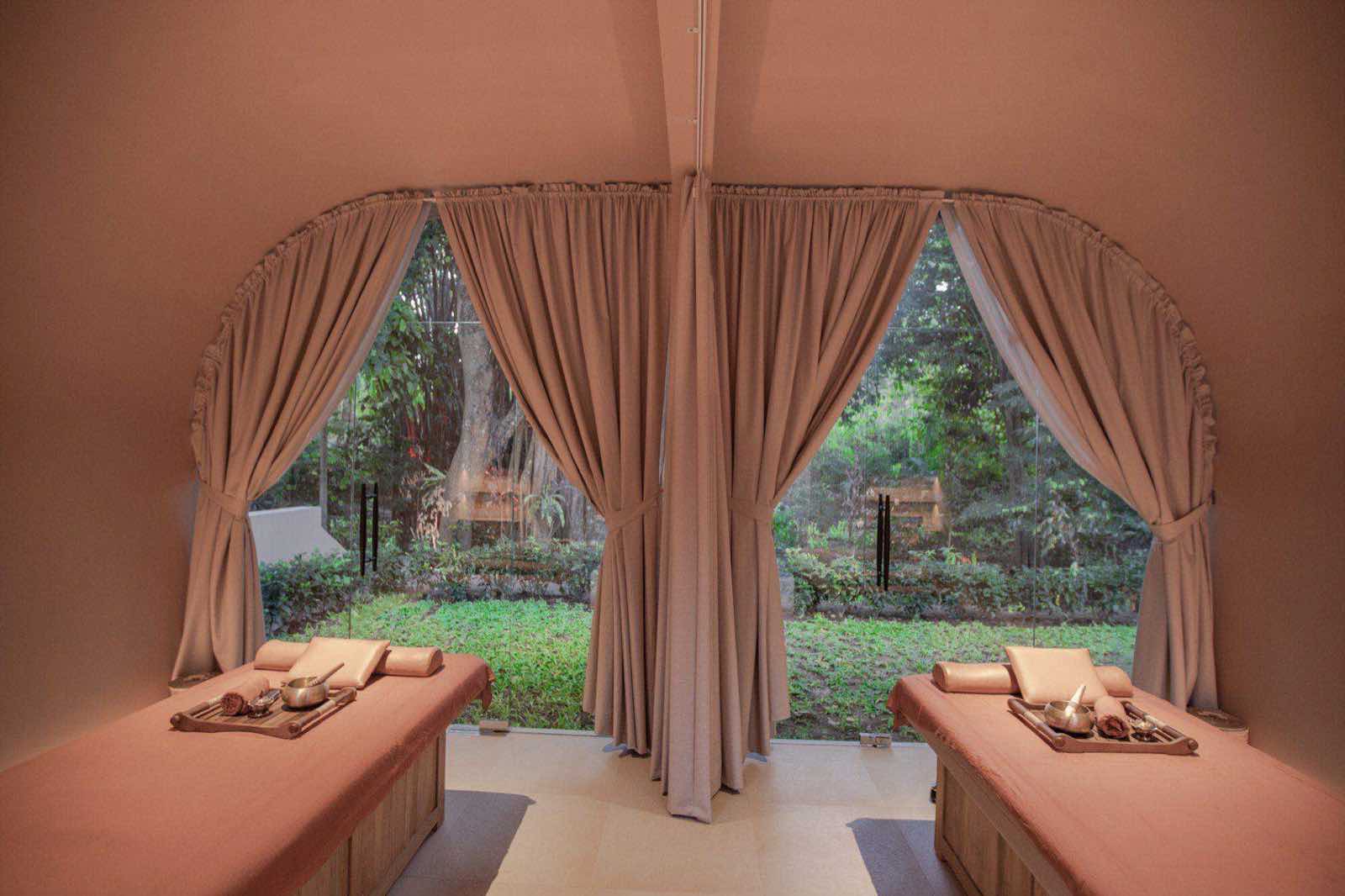 A treatment room opening to the jungle through curtained arches