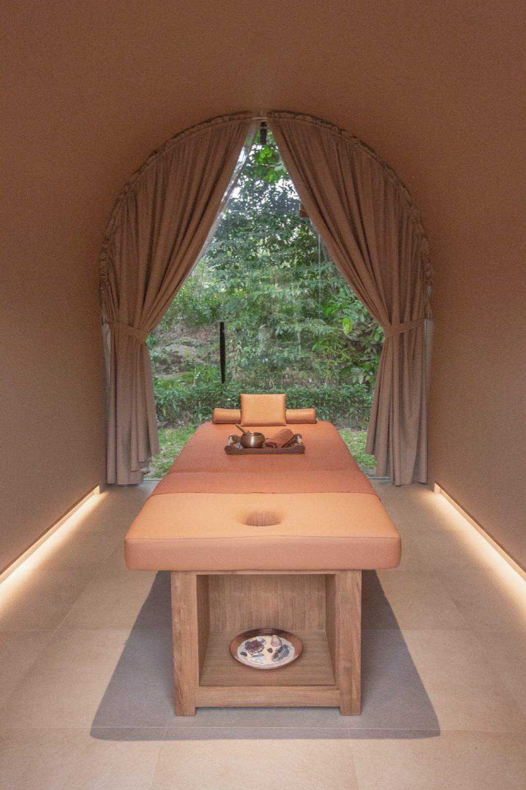A massage table beneath an arched window